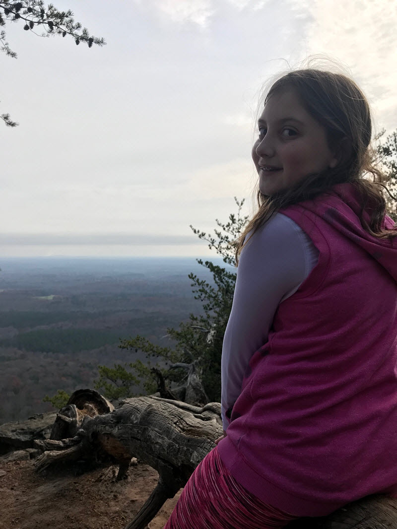 A young girl takes in the view from atop Crowder's Mountain