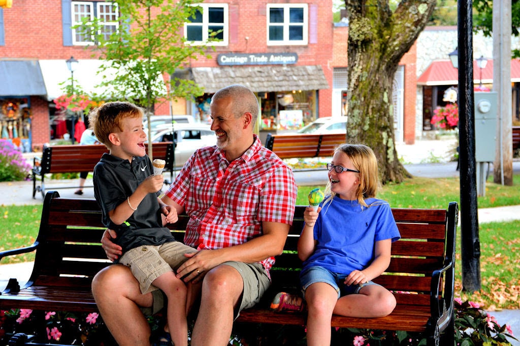 Father and children enjoy ice cream on a bench in Blowing Rock