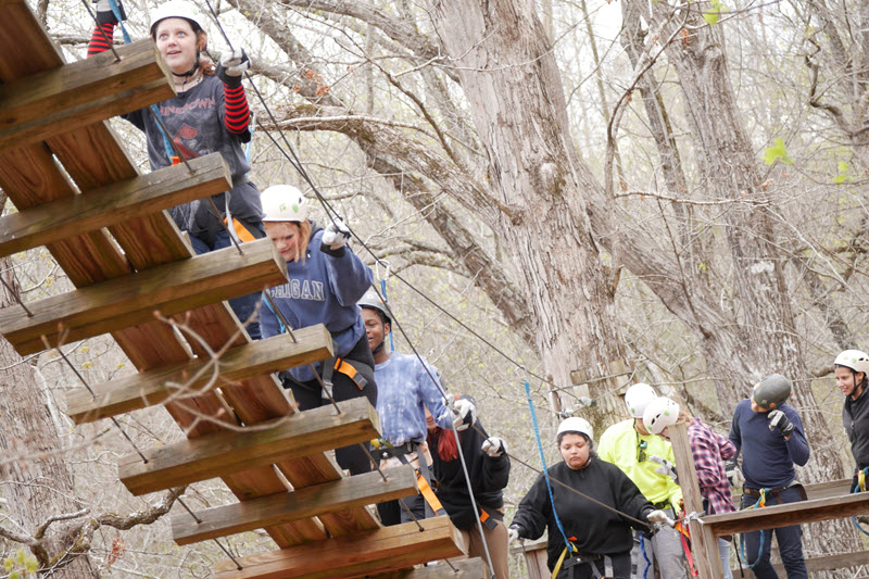 children climb the ropes course obstacles at Richland Creek Zipline