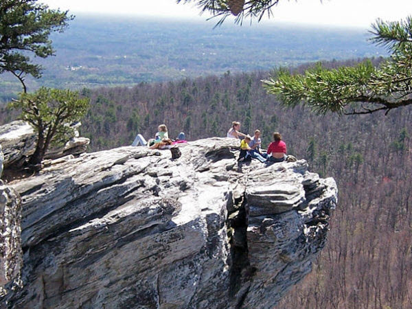 Adventurous hikers linger on the overhang of Hanging Rock State Park
