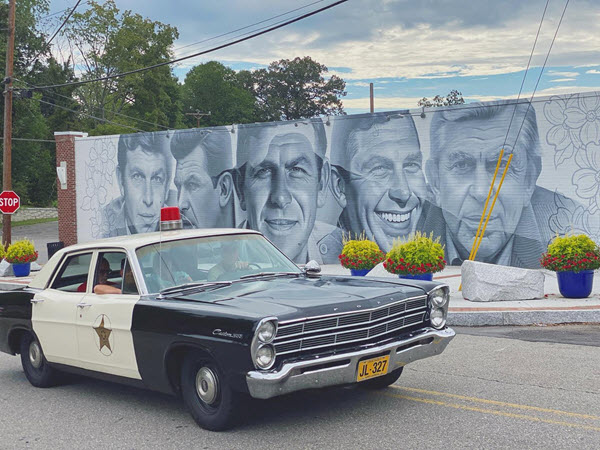 A squad car parked in front of the Andy Griffith mural in Mount Airy NC