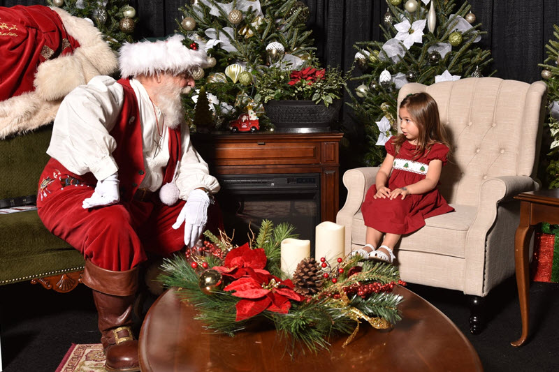 a little girl shares her wish list with Santa