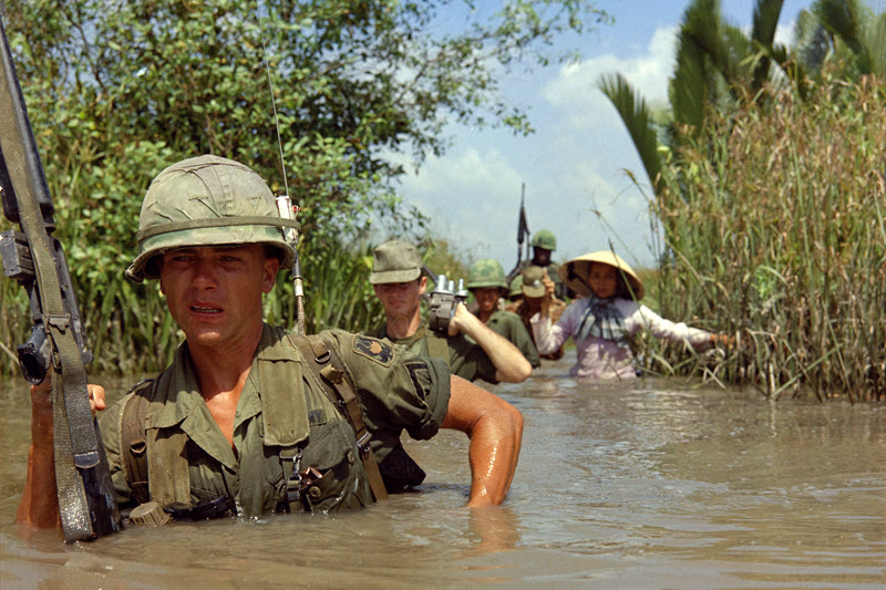 A US soldier wades through muddy water in Vietnam