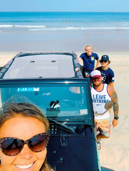 A family drives a rented Jeep onto the beach in Corolla