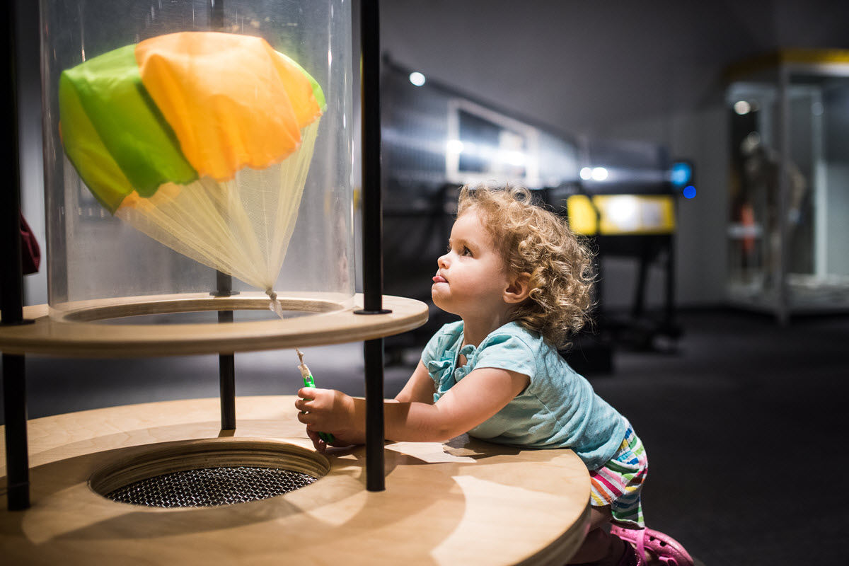 A child test a toy parachute at the Museum of Life and Science