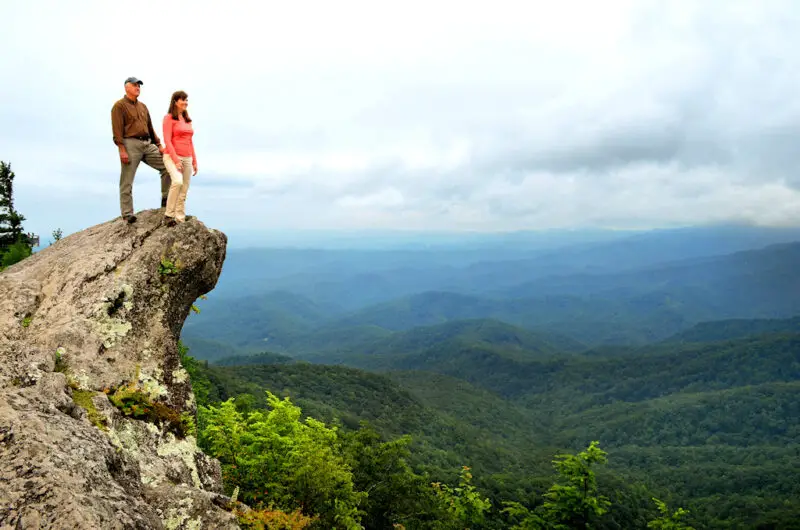 A couple standing on top of Blowing Rock NC