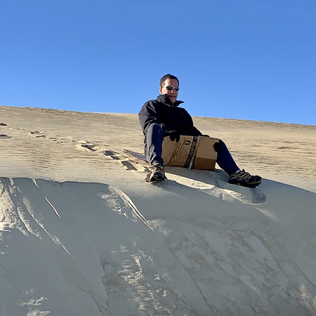 man tries dune sledding at Jockey's Ridge in the Outer Banks