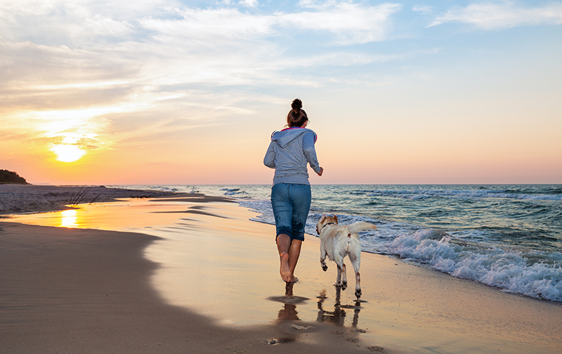 A woman running on one of several dog friendly beaches South Carolina.