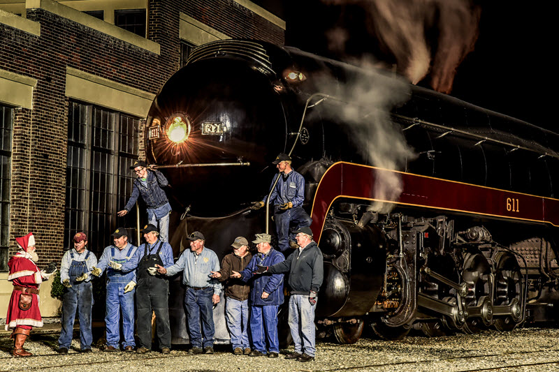 Santa hands lumps of coal to the crew of the 611 steam train