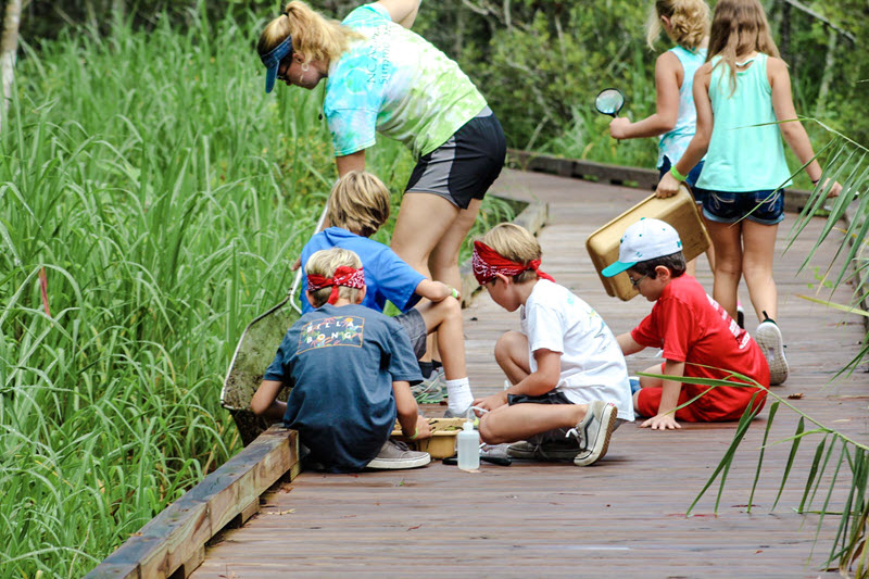 School kids and instructor on a boardwalk at the Eastern 4-H Center in Columbia, NC