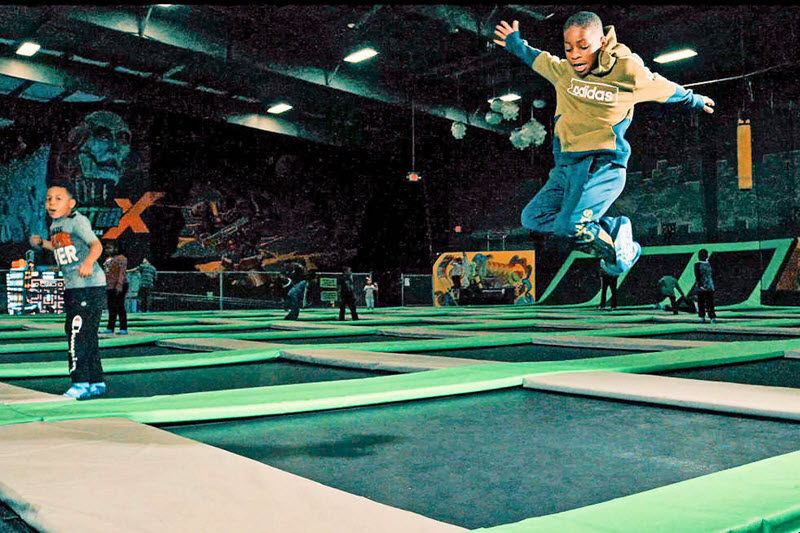 Children bounce during day trips to an indoor trampoline park.