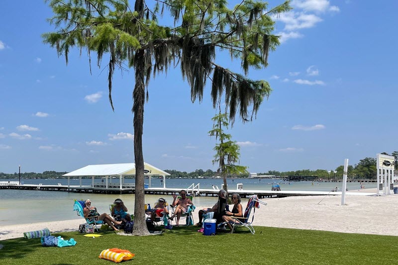 Guests find shade at the White Lake beach at Camp Clearwater