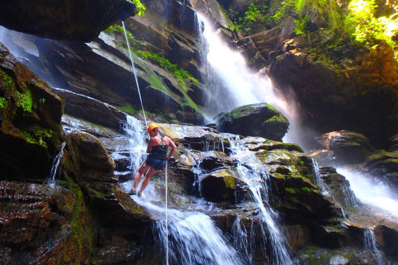 A woman rappels down a waterfall in Saluda, NC
