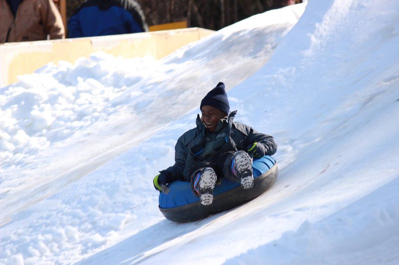 Young boy riding a snow tube at Jonas Ridge