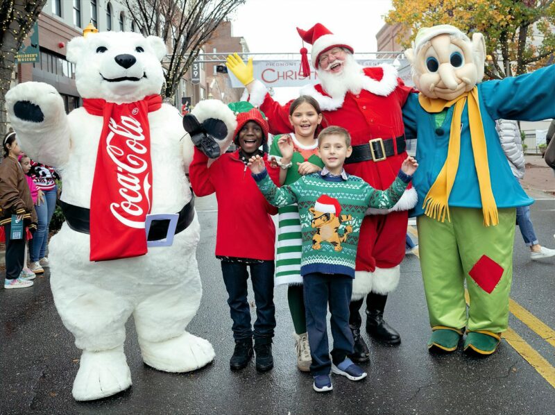 Children posing with costumed figures in the Christmasville in Rock Hill parade.