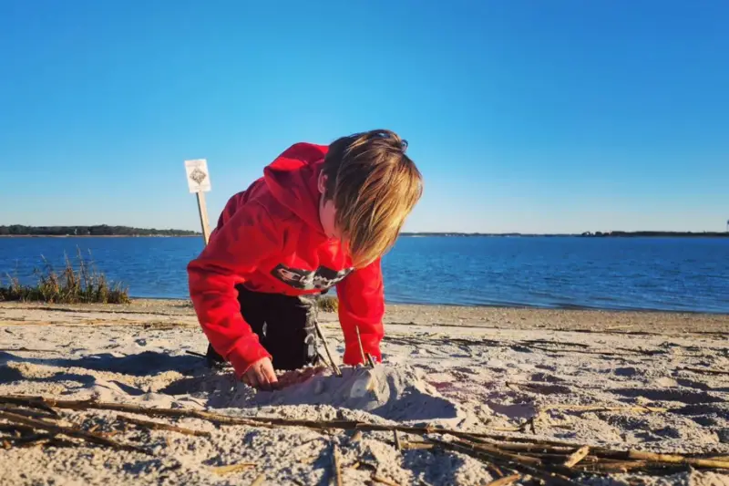 Kid playing in the sand at the Sands in Port Royal SC.