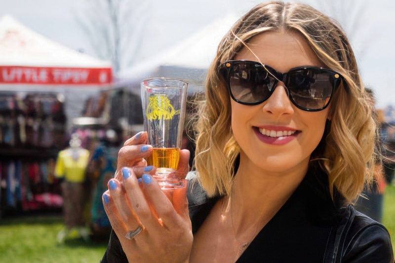 Woman holding a tasting glass of beer at a food festival