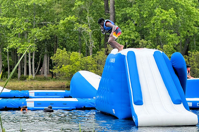 A boy leaps from a water obstacle at the Charleston Aqua Park