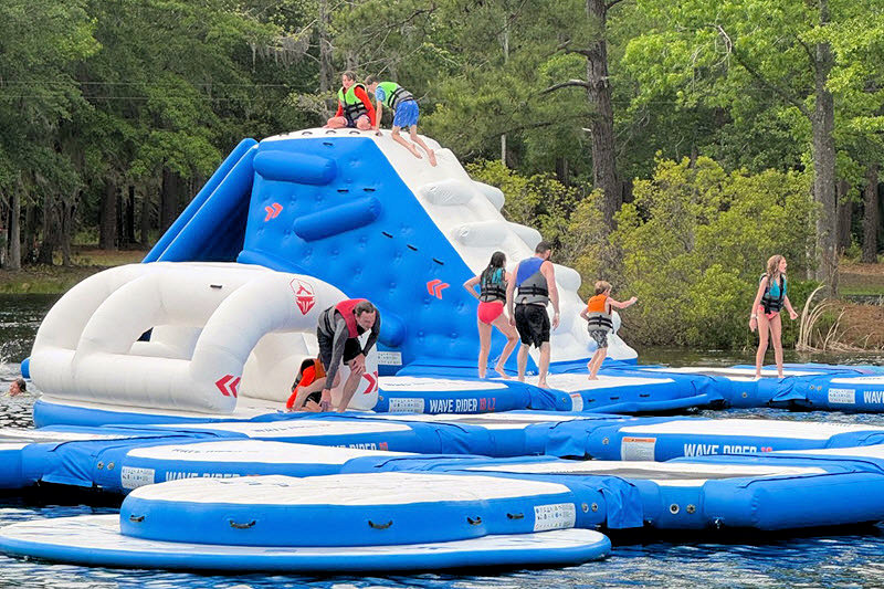 Kids playing on a water obstacle course at the Charleston Aqua Park