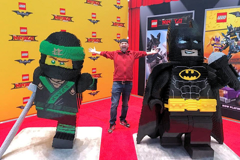 Man poses with life size LEGO models of Batman and Ninjago