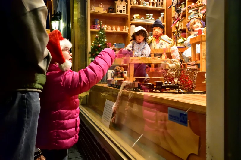Boy peers through shop window at Christmas