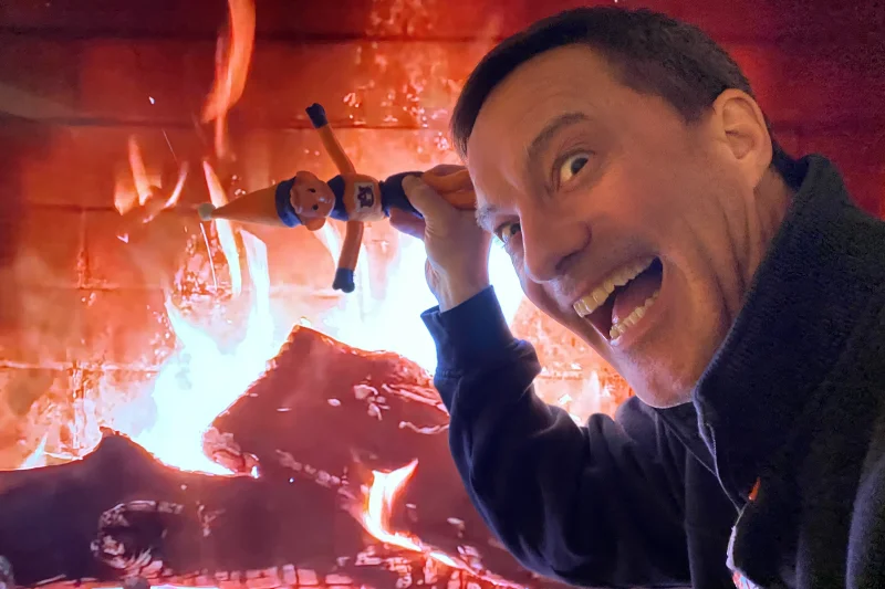 Dave dangles Elf On A Shelf over the Yule Log