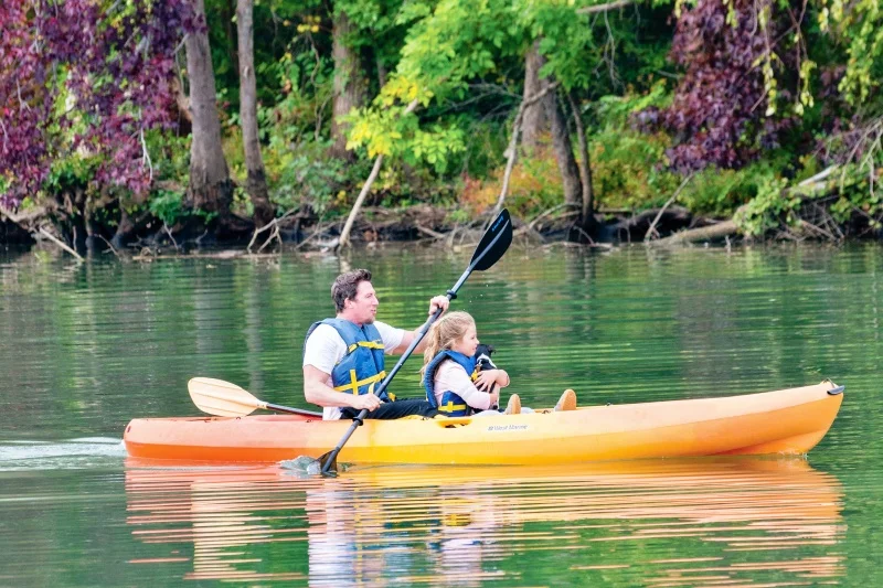 father, daughter, and puppy kayak on the Catawba River in Gaston County, NC